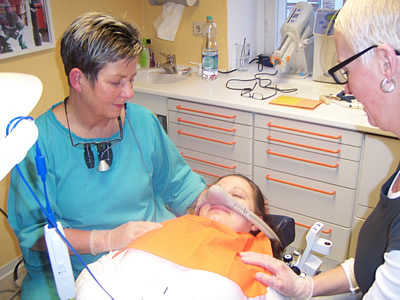 Zeigt eine Patientin auf dem Behandlungsstuhl mit der Nasenmaske